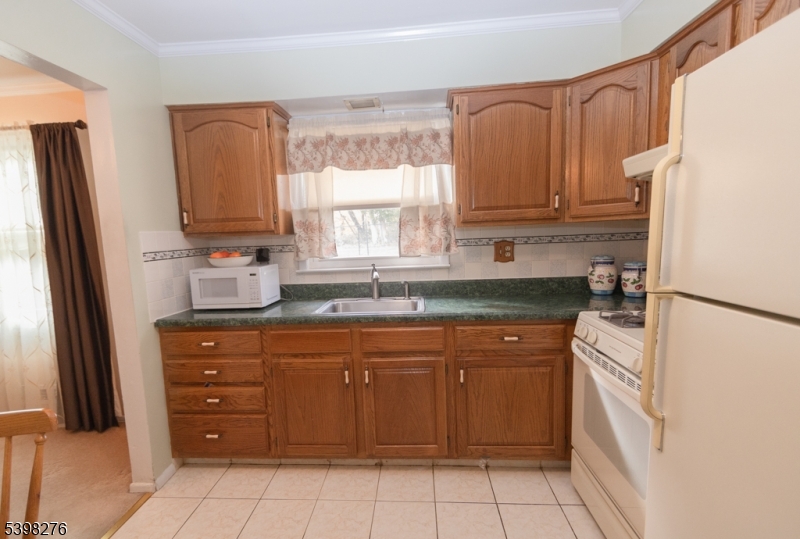 169 Valley View Road Hillside, NJ 07205 - Photo 19 of 32 a kitchen with a refrigerator sink and cabinets