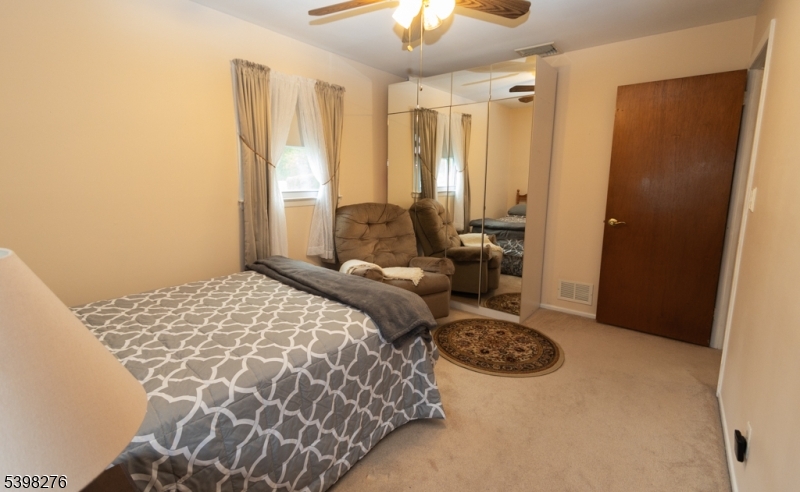 169 Valley View Road Hillside, NJ 07205 - Photo 10 of 32 a bedroom with a bed and a chandelier