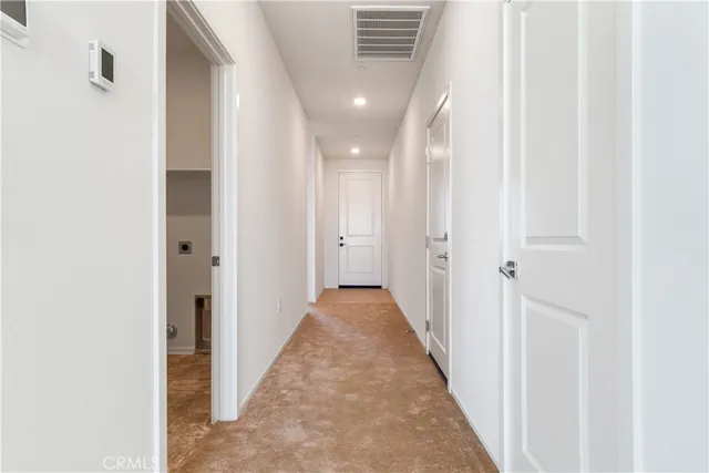 a view of a hallway with wooden floor and entryway