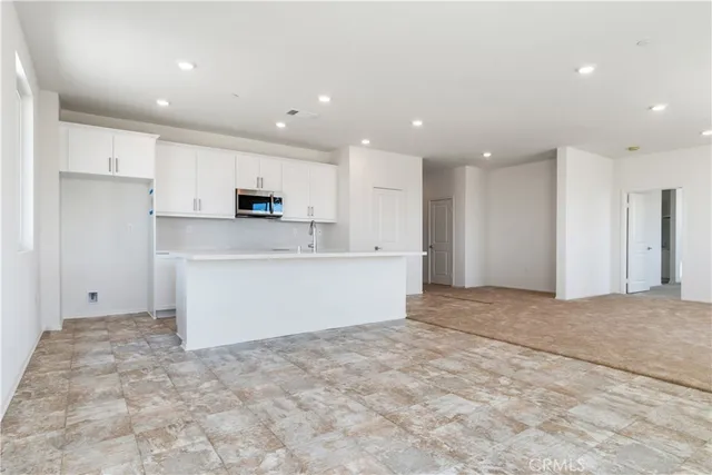 a view of kitchen with kitchen island a sink stainless steel appliances and cabinets