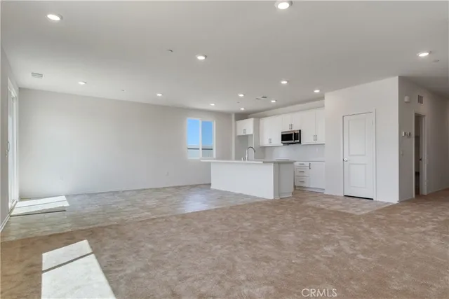 a view of a kitchen with a sink and white cabinets