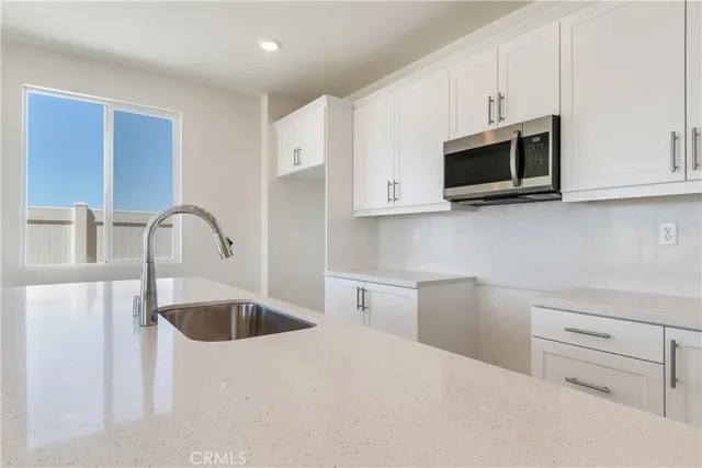 a kitchen with appliances a sink and cabinets