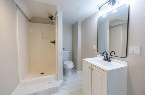 a bathroom with a sink a toilet and shower