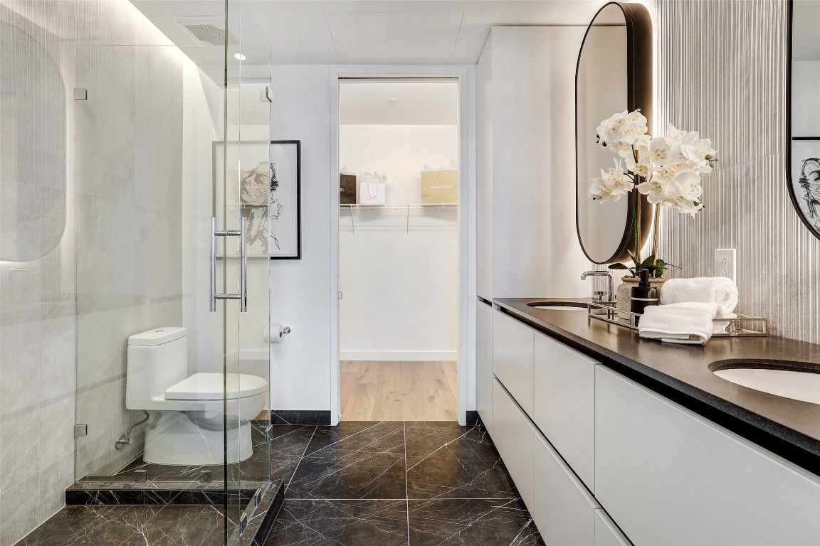 610 Davis Street, Unit 3008 Austin, TX 78701 - Photo 13 of 39 a bathroom with a double vanity sink a toilet and a mirror