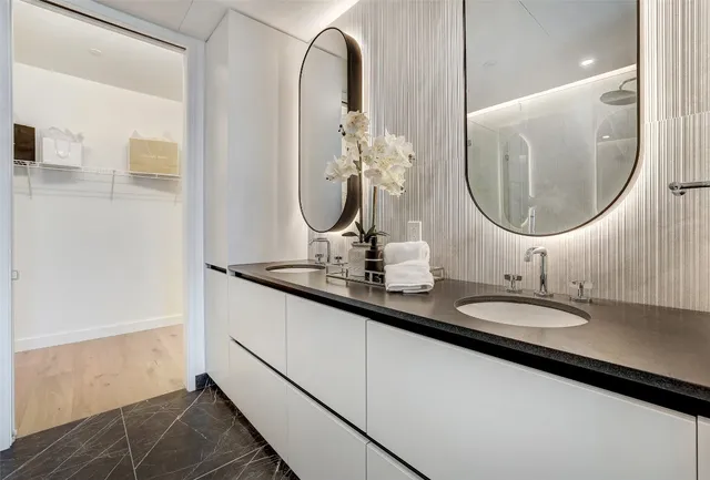 a bathroom with a double vanity sink and a mirror