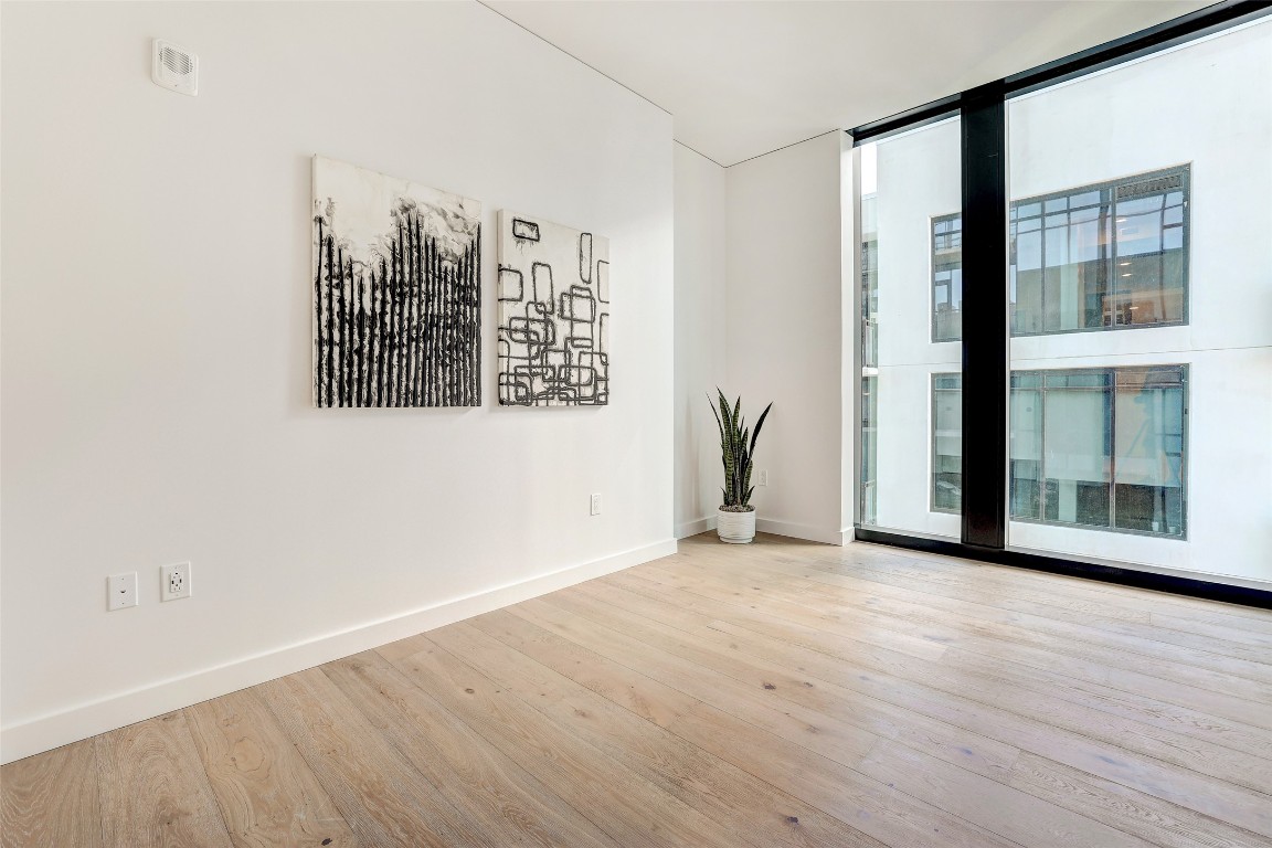610 Davis Street, Unit 3008 Austin, TX 78701 - Photo 20 of 39 an empty room with wooden floor and windows