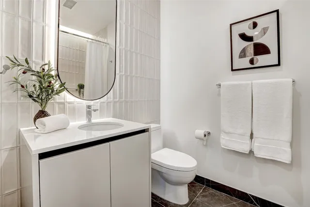 a bathroom with a toilet sink and mirror