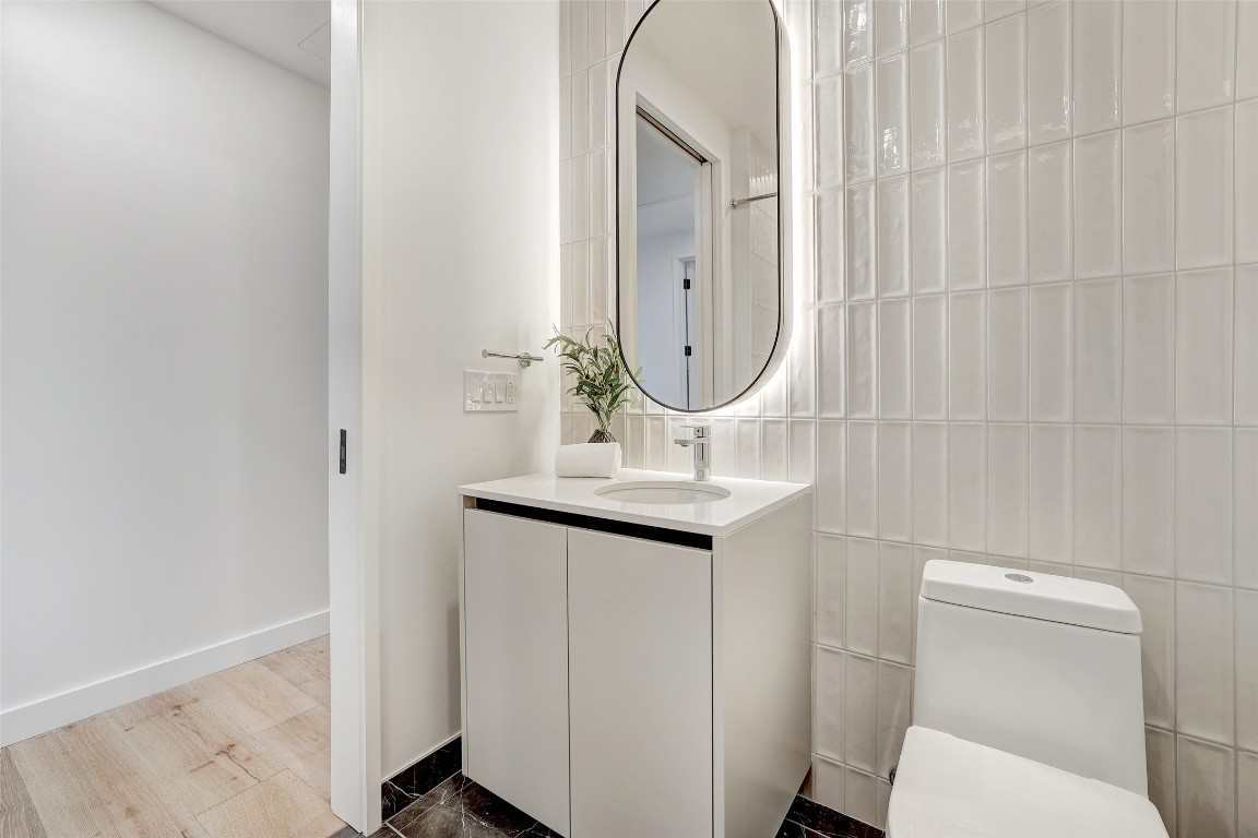 610 Davis Street, Unit 3008 Austin, TX 78701 - Photo 25 of 39 a bathroom with a toilet a sink and mirror