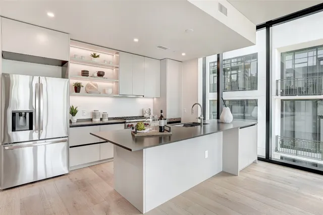 a kitchen with stainless steel appliances granite countertop a refrigerator and a stove top oven