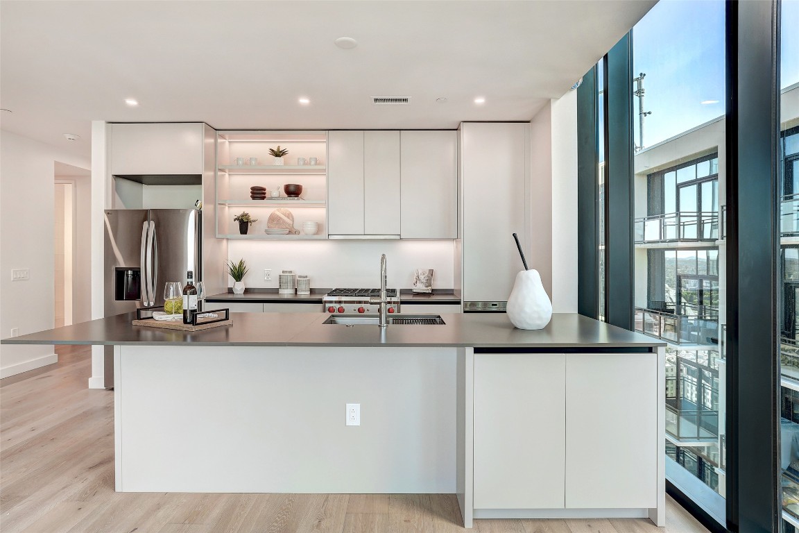610 Davis Street, Unit 3008 Austin, TX 78701 - Photo 6 of 39 a kitchen with kitchen island granite countertop a sink cabinets and wooden floor