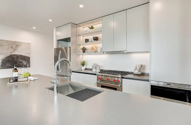 a kitchen with kitchen island granite countertop a sink cabinets and wooden floor