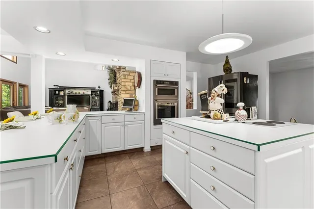 a kitchen with white cabinets and appliances