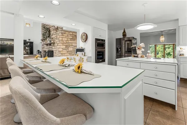 a view of kitchen with kitchen island a stove a dining table and chairs
