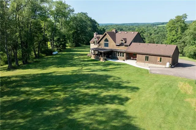 a view of a house with a big yard potted plants and large tree