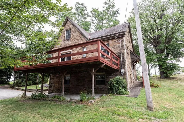 a view of a house with a yard balcony and a tree