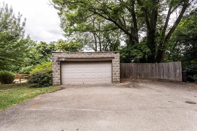 a backyard of a house with large trees and a barn