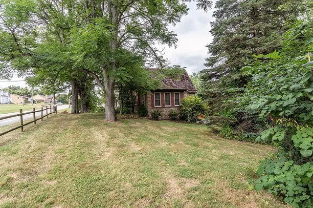 a view of a house with backyard and tree