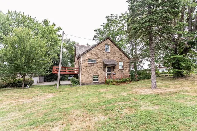 a view of a house with a yard and sitting area