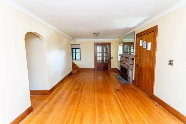 a spacious bedroom with a bed and wooden floor