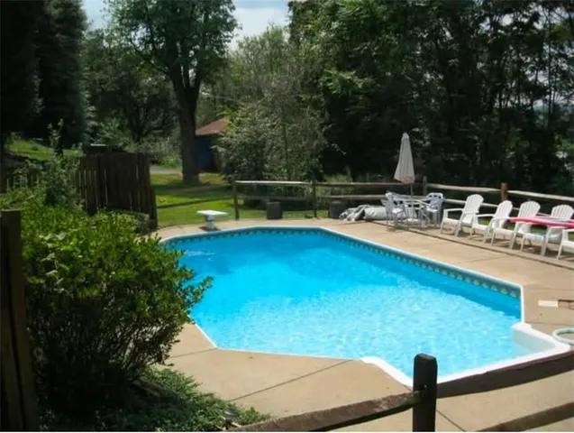a view of a swimming pool with a patio and a garden