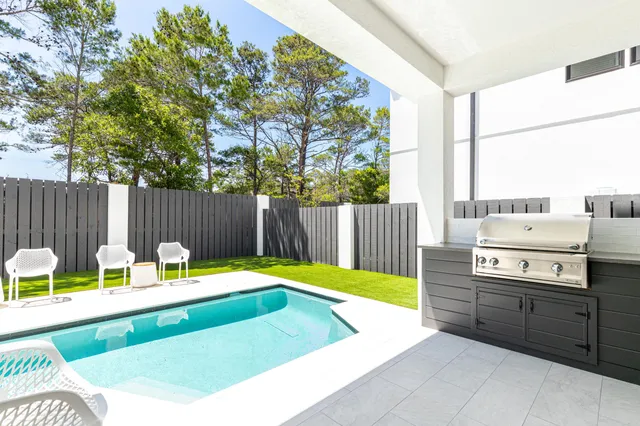 a view of a chairs and table in the back yard of the house