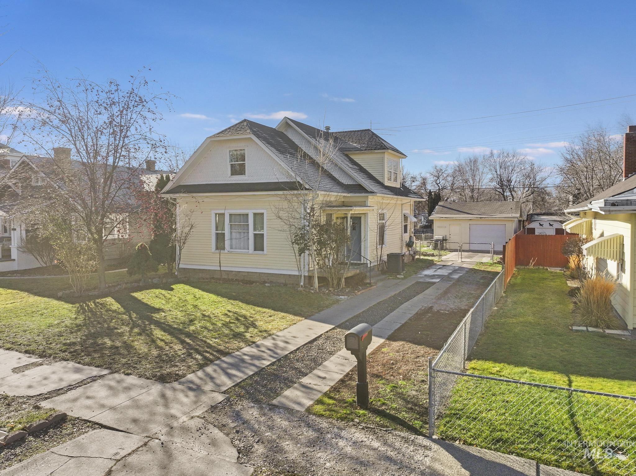 View of front of property featuring driveway and a shingled roof