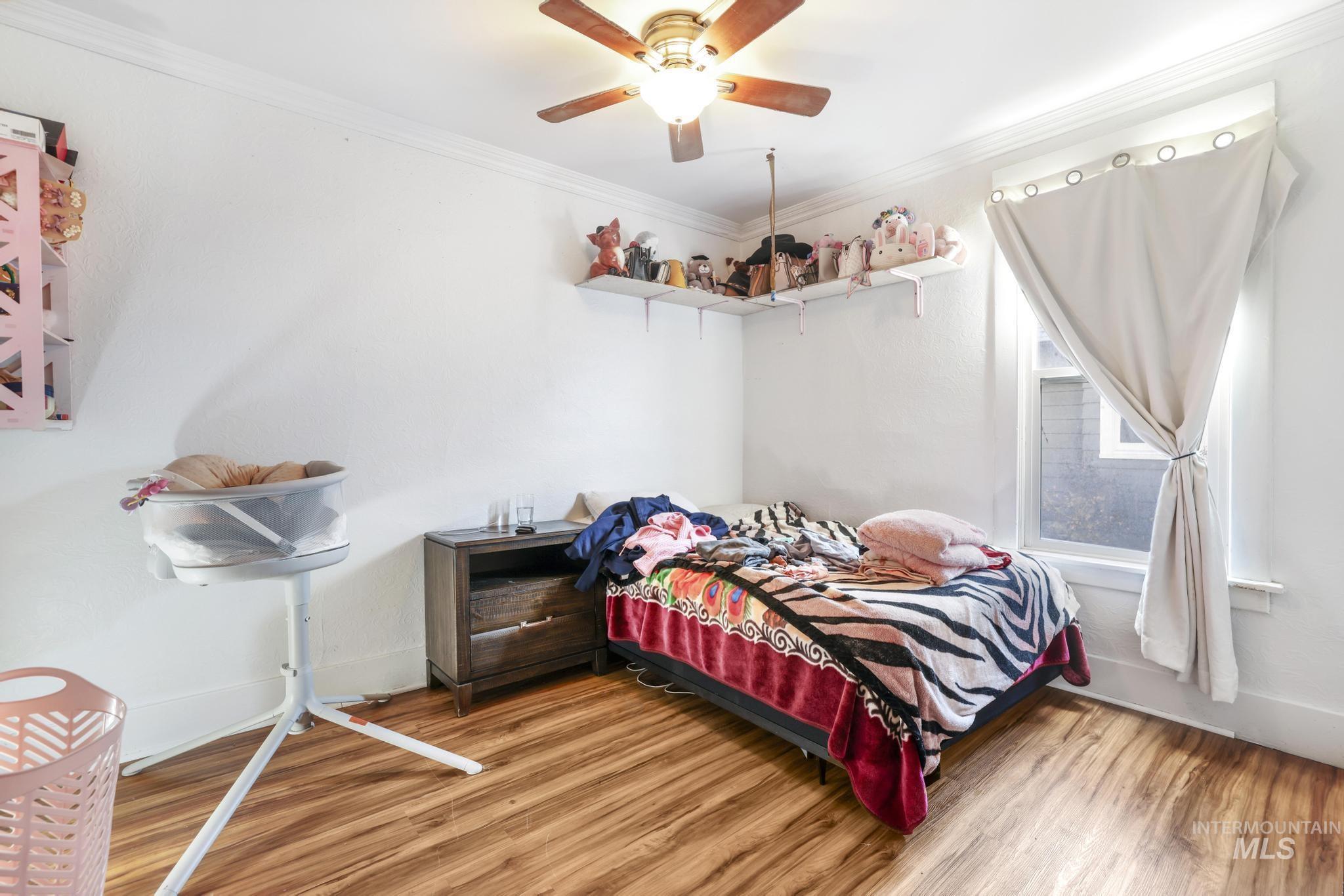 242 8th Avenue East Twin Falls, ID 83301 - Photo 14 of 35 Bedroom with crown molding, wood finished floors, and ceiling fan