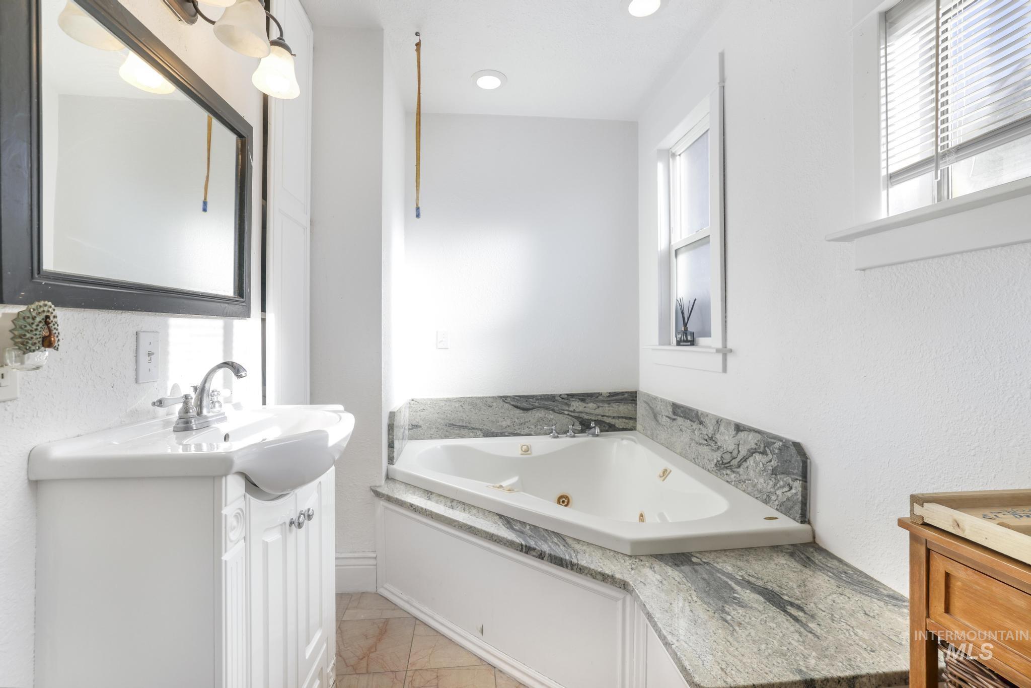 242 8th Avenue East Twin Falls, ID 83301 - Photo 16 of 35 Full bath featuring vanity, a whirlpool tub, a textured wall, and recessed lighting