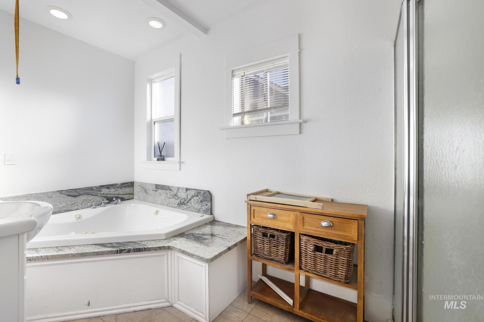 242 8th Avenue East Twin Falls, ID 83301 - Photo 17 of 35 Full bathroom with a garden tub, vanity, a shower stall, and light tile patterned floors