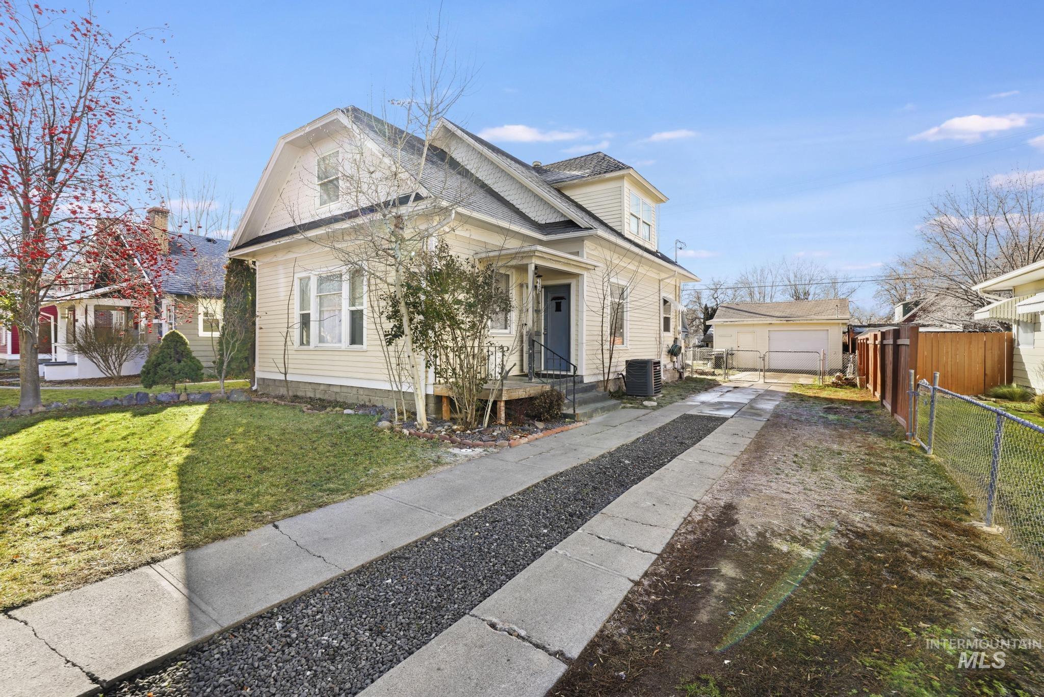 242 8th Avenue East Twin Falls, ID 83301 - Photo 2 of 35 View of front facade with an outbuilding, a garage, roof with shingles, and driveway