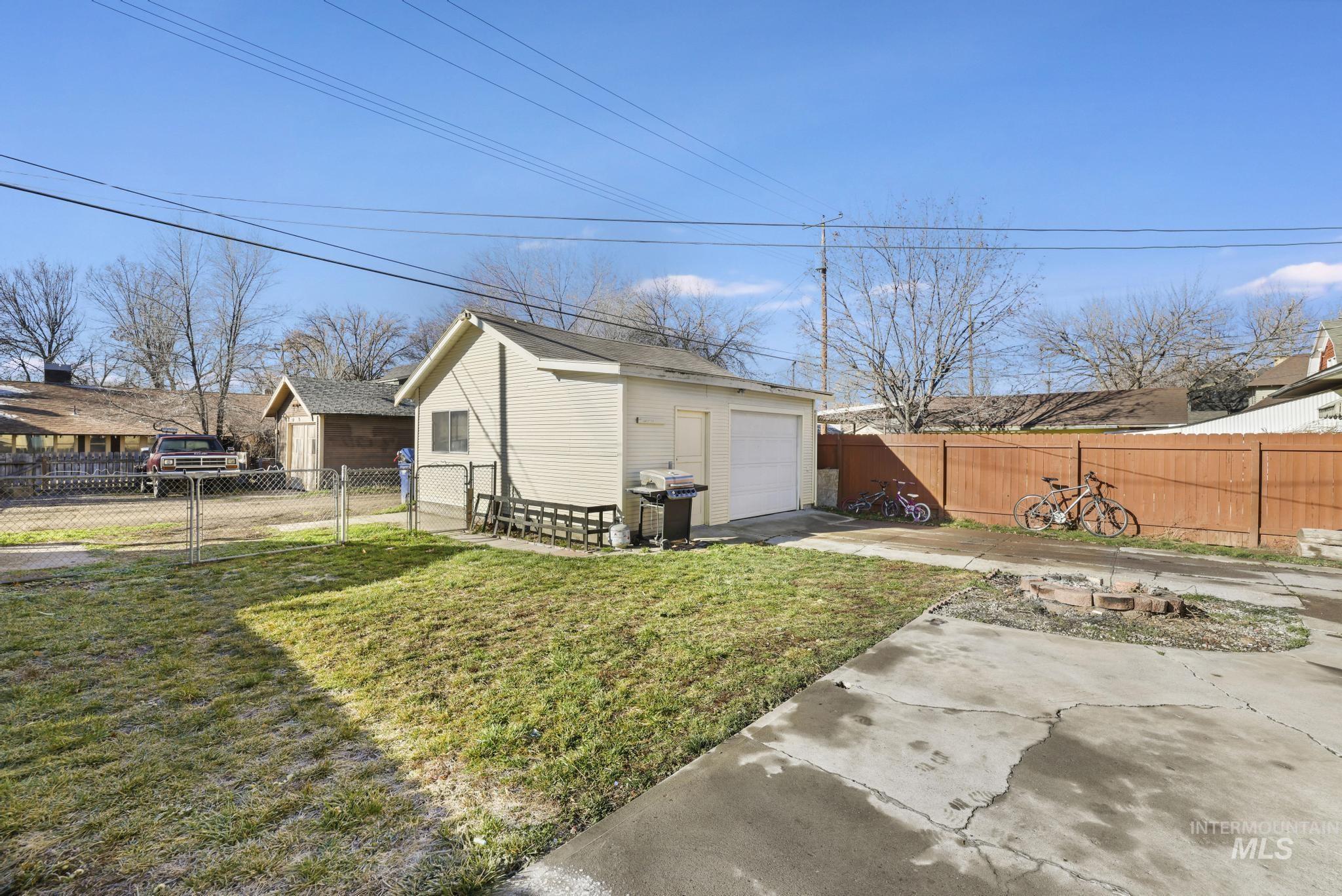 242 8th Avenue East Twin Falls, ID 83301 - Photo 32 of 35 Fenced backyard with an outbuilding, driveway, and a detached garage