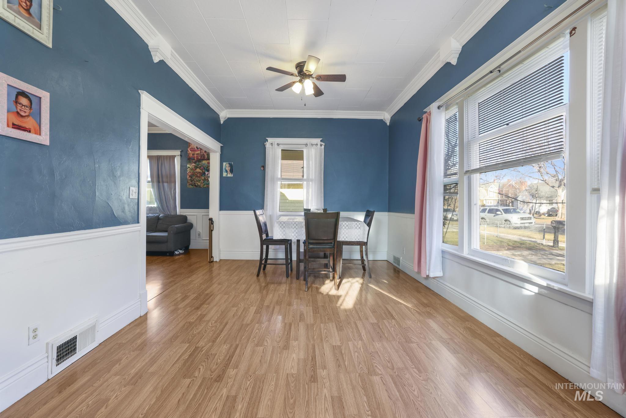 242 8th Avenue East Twin Falls, ID 83301 - Photo 8 of 35 Dining area with light wood-style floors, ceiling fan, ornamental molding, and a wainscoted wall