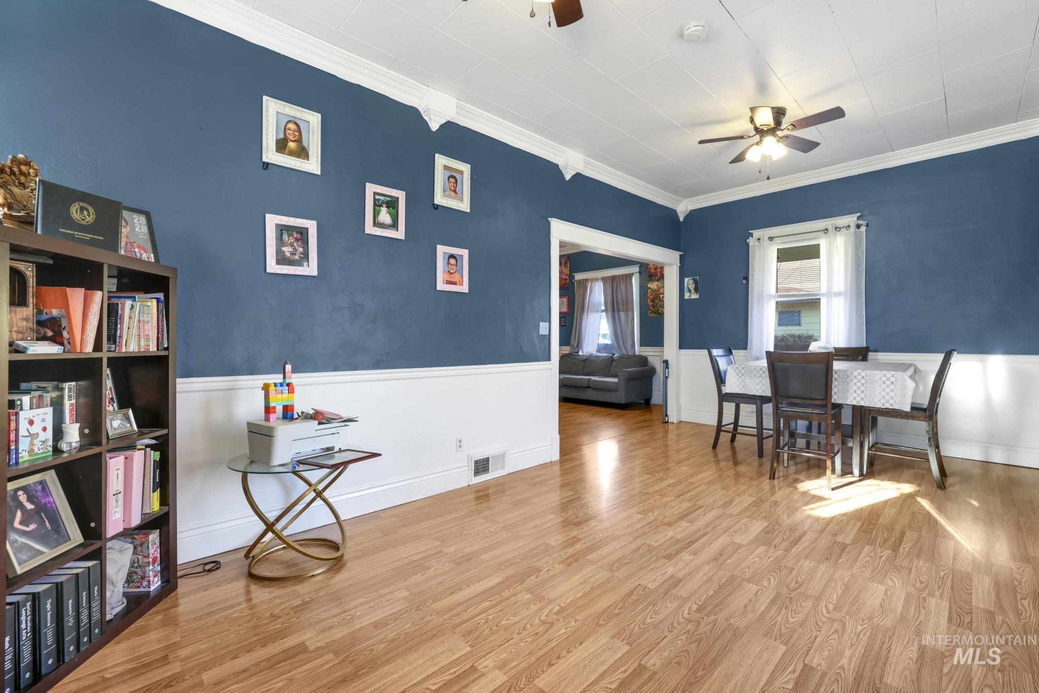 242 8th Avenue East Twin Falls, ID 83301 - Photo 9 of 35 Dining area featuring wood finished floors, a ceiling fan, wainscoting, and crown molding