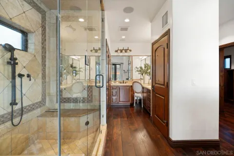 a bathroom with a glass shower door and a sink