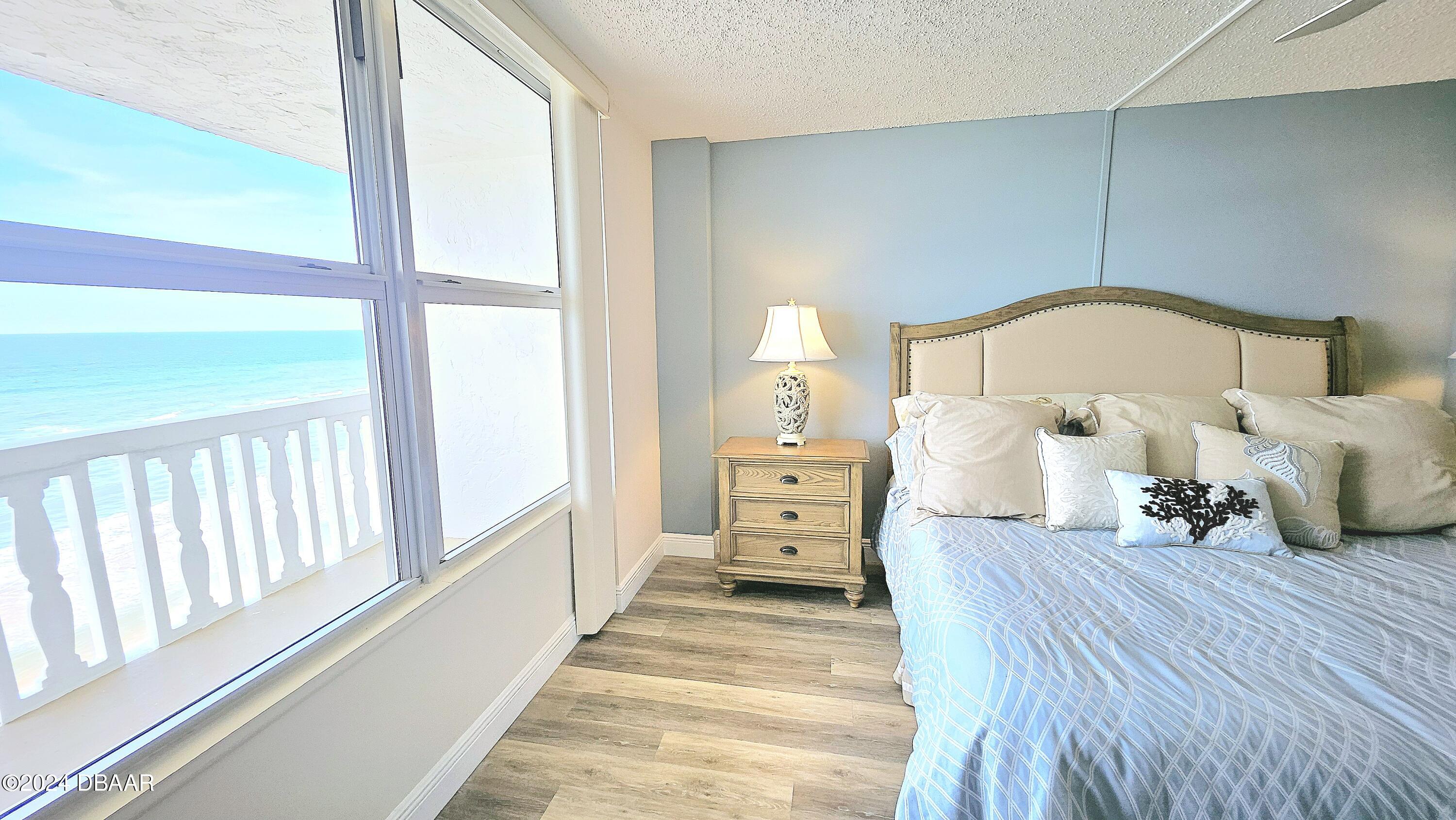 1575 Ocean Shore Boulevard, Unit 1003 Ormond Beach, FL 32176 - Photo 12 of 40 a bedroom with bed and a large window