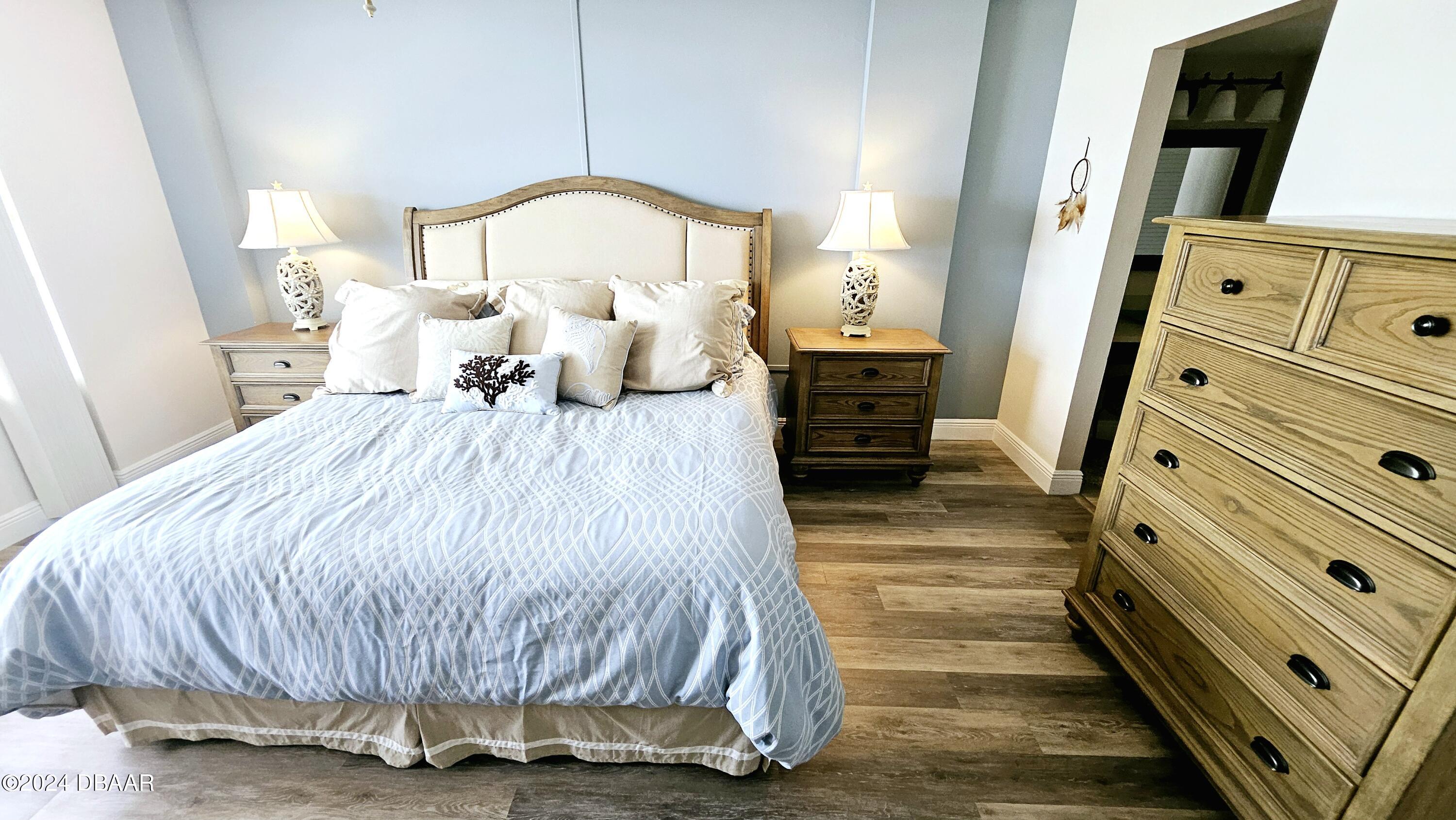 1575 Ocean Shore Boulevard, Unit 1003 Ormond Beach, FL 32176 - Photo 15 of 40 a bedroom with a bed and a mirror on dresser