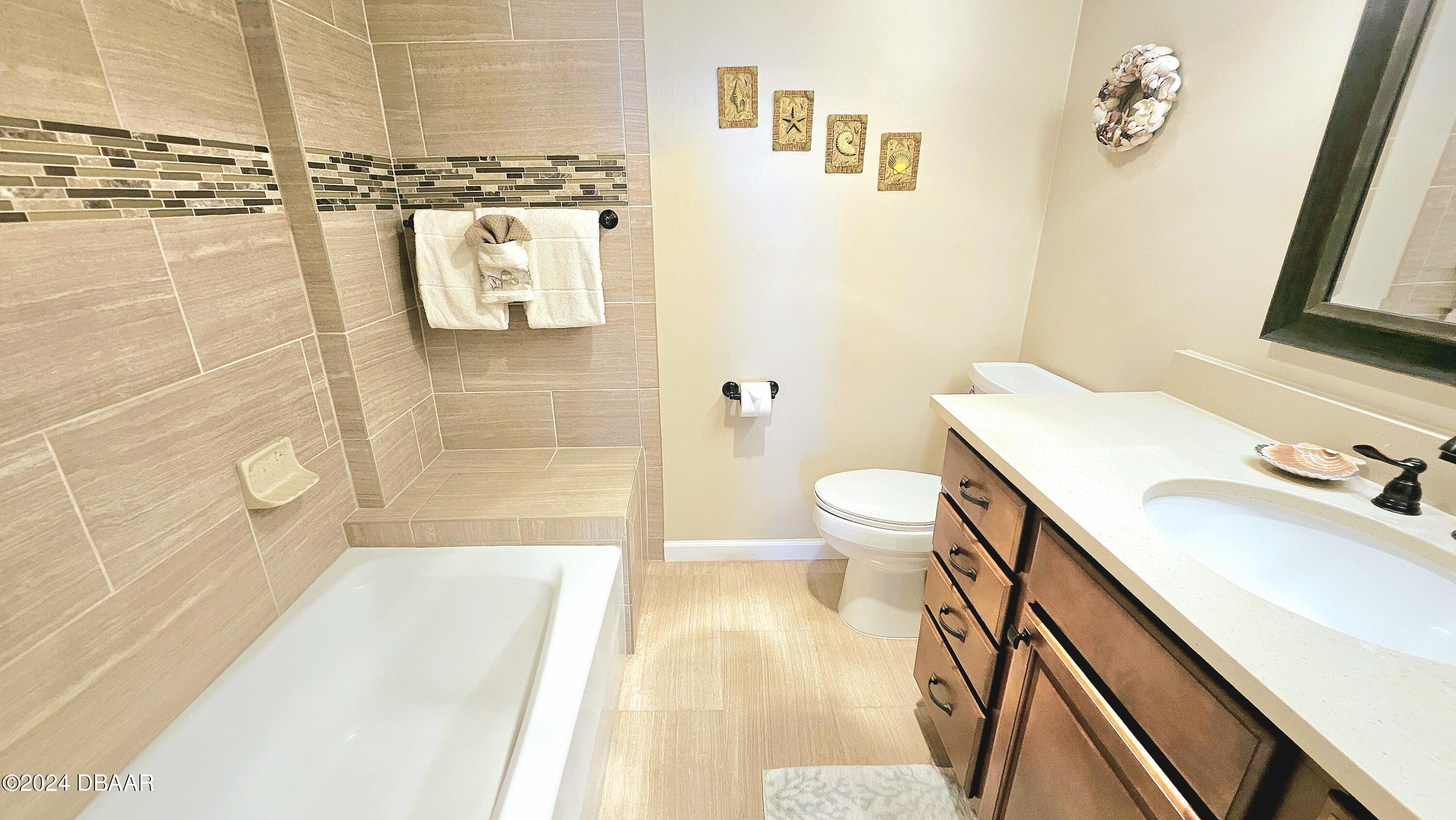 1575 Ocean Shore Boulevard, Unit 1003 Ormond Beach, FL 32176 - Photo 16 of 40 a bathroom with a sink a toilet and shower