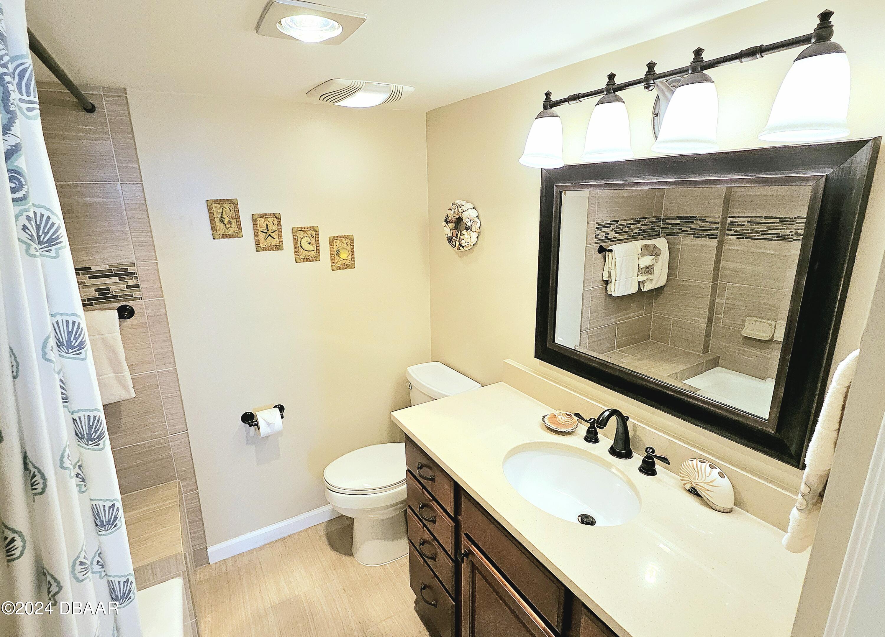 1575 Ocean Shore Boulevard, Unit 1003 Ormond Beach, FL 32176 - Photo 19 of 40 a bathroom with a sink vanity mirror and toilet