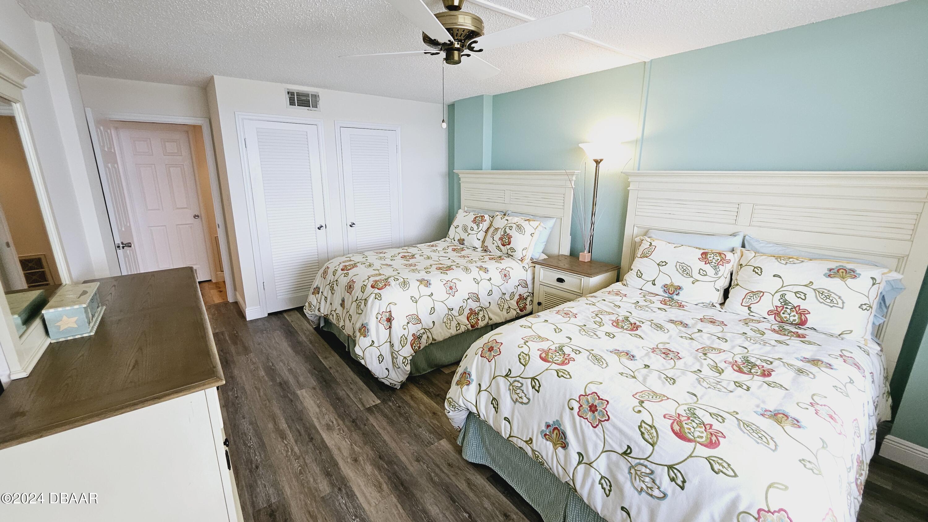 1575 Ocean Shore Boulevard, Unit 1003 Ormond Beach, FL 32176 - Photo 23 of 40 a bedroom with two beds and a chandelier