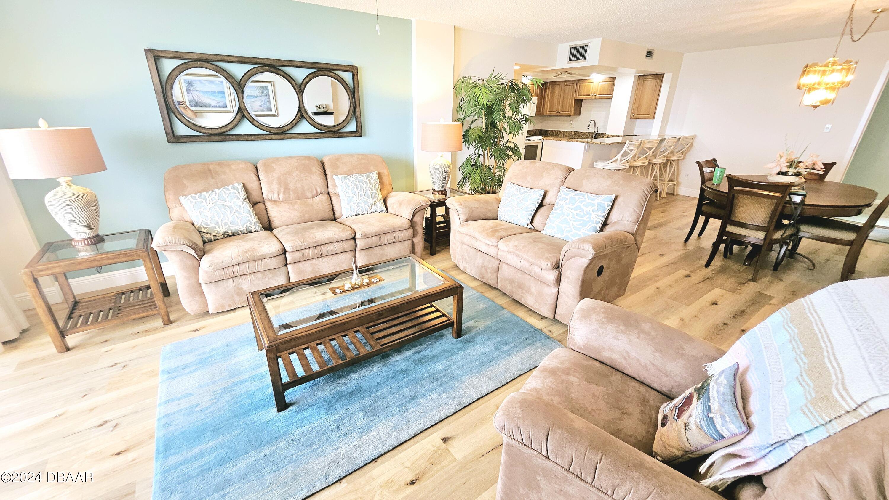 1575 Ocean Shore Boulevard, Unit 1003 Ormond Beach, FL 32176 - Photo 4 of 40 a living room with furniture and a painting on the wall