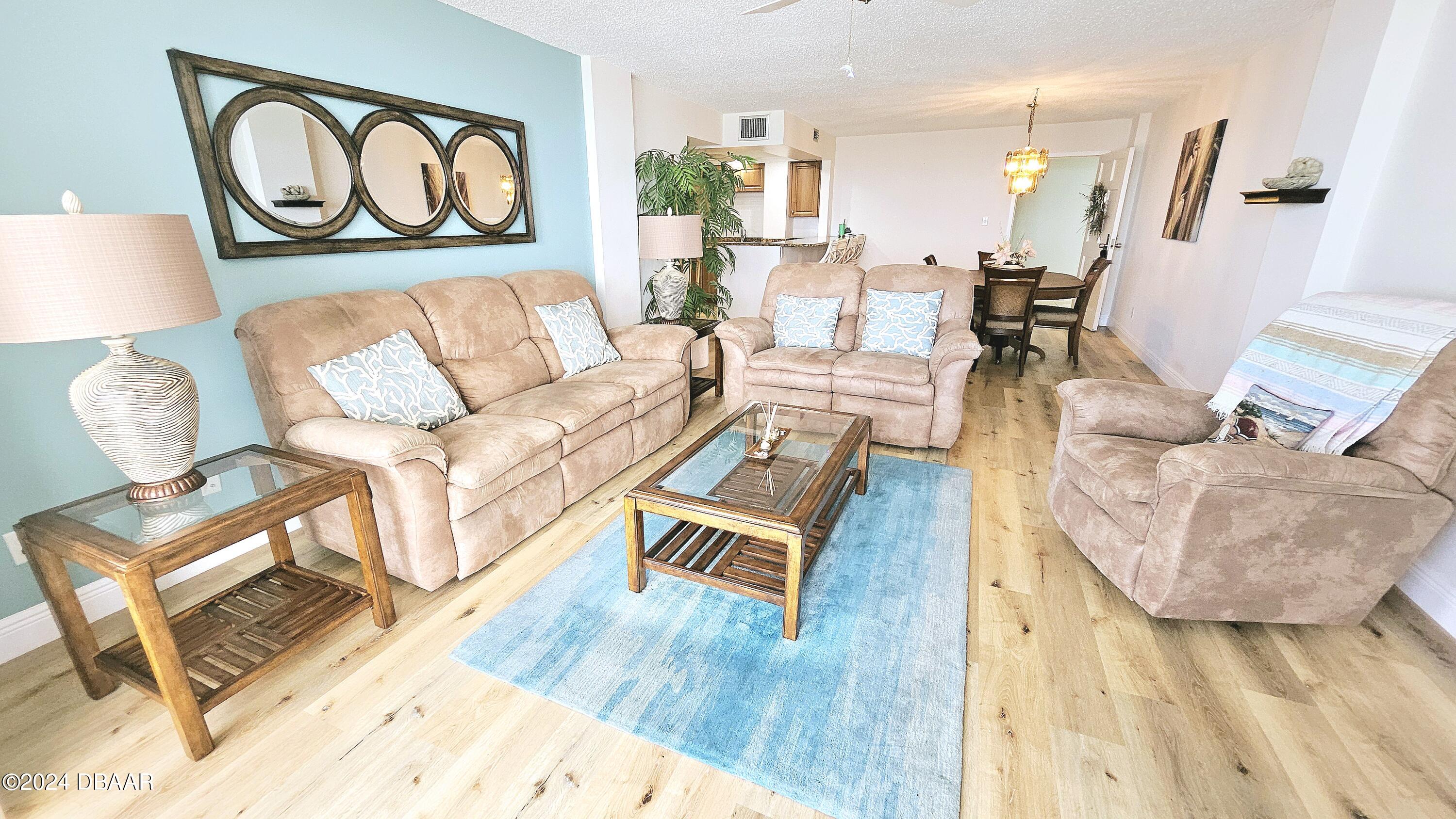 1575 Ocean Shore Boulevard, Unit 1003 Ormond Beach, FL 32176 - Photo 6 of 40 a living room with furniture and a wooden floor