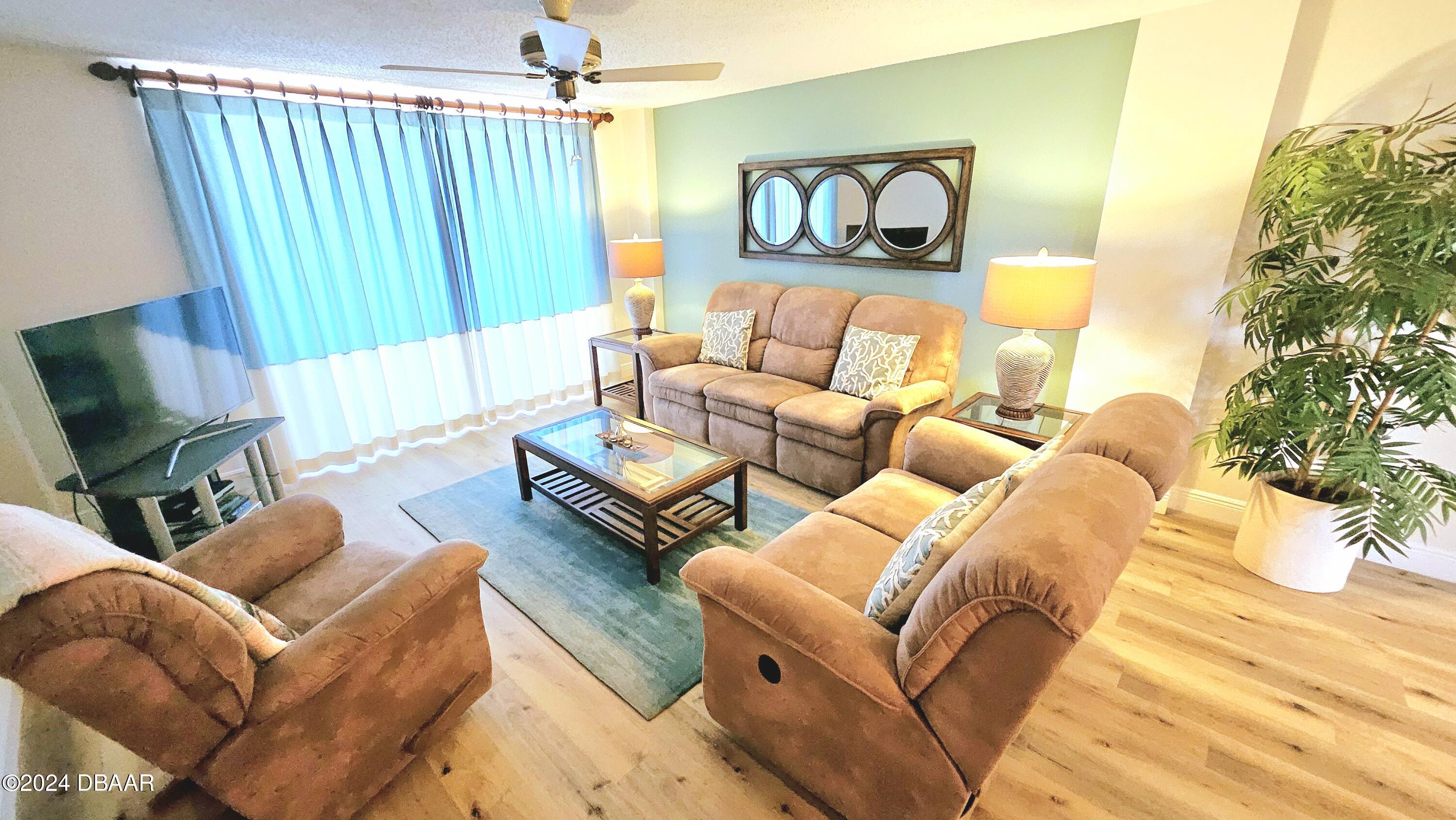 1575 Ocean Shore Boulevard, Unit 1003 Ormond Beach, FL 32176 - Photo 7 of 40 a living room with furniture and a flat screen tv