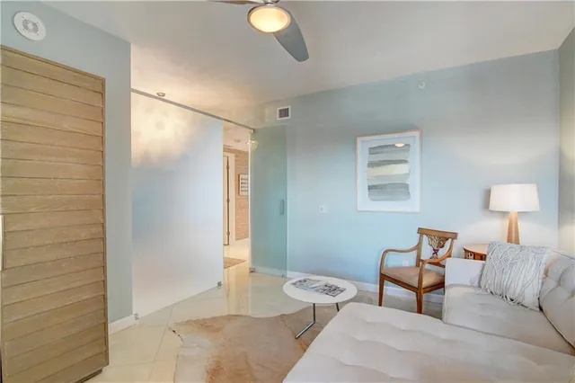 a living room with furniture kitchen view and a potted plant
