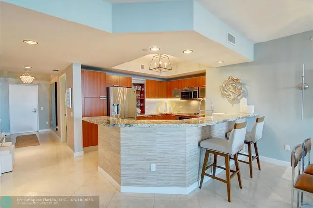 a view of a swimming pool with a table and chairs under an umbrella