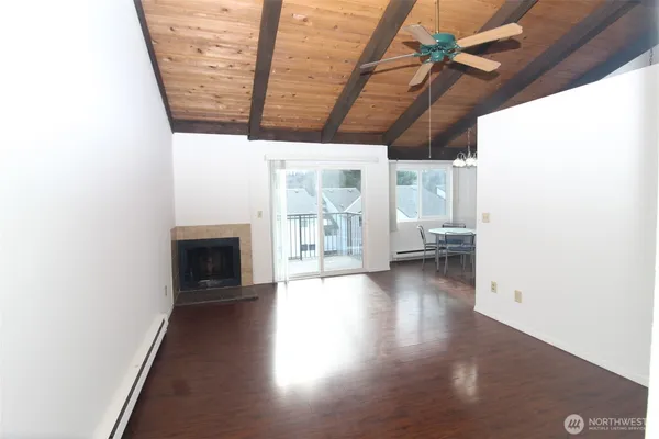 a view of a hallway with wooden floor and furniture