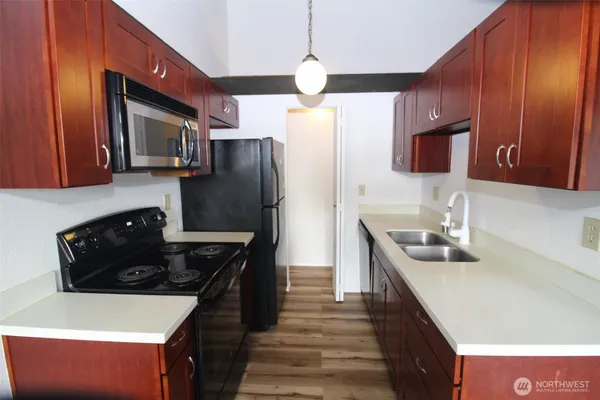 a large kitchen with a sink a refrigerator and a stove