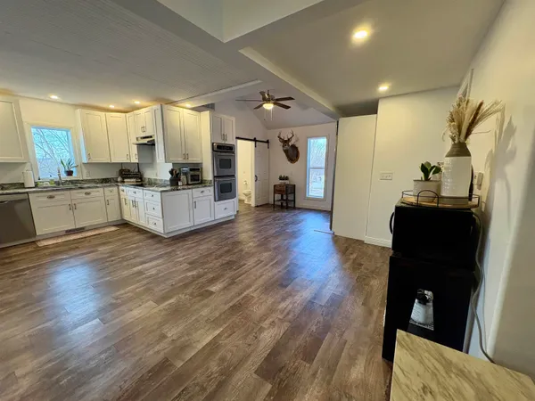 a large white kitchen with sink and refrigerator