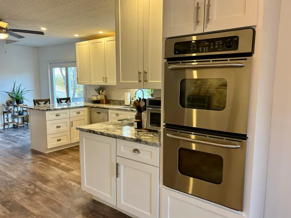 a kitchen with granite countertop cabinets stainless steel appliances and wooden floor