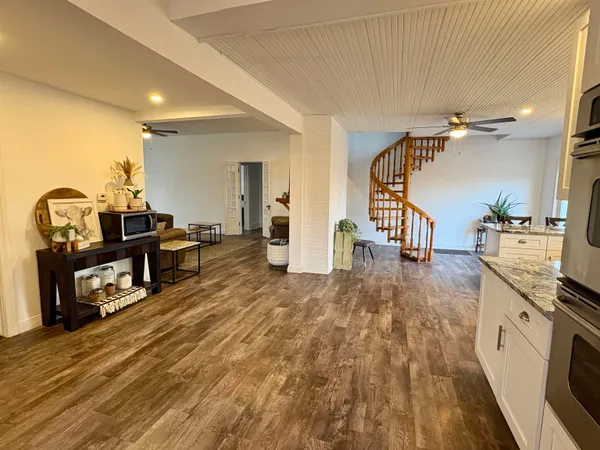 a living room with furniture and a wooden floor