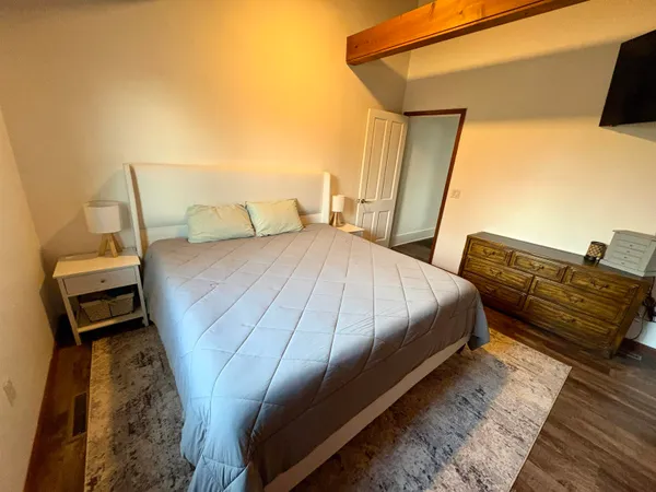 a bedroom with a bed and wooden floor